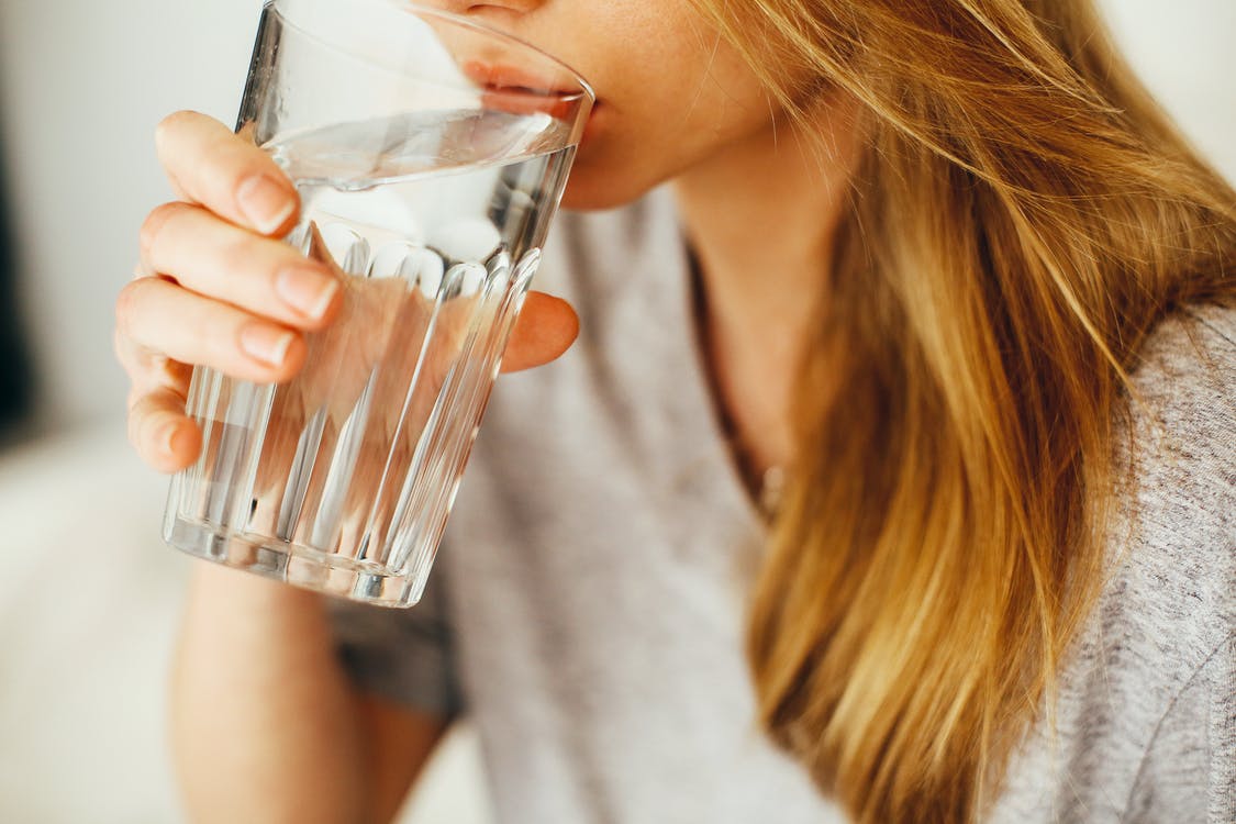 blonde woman holding a glass of water