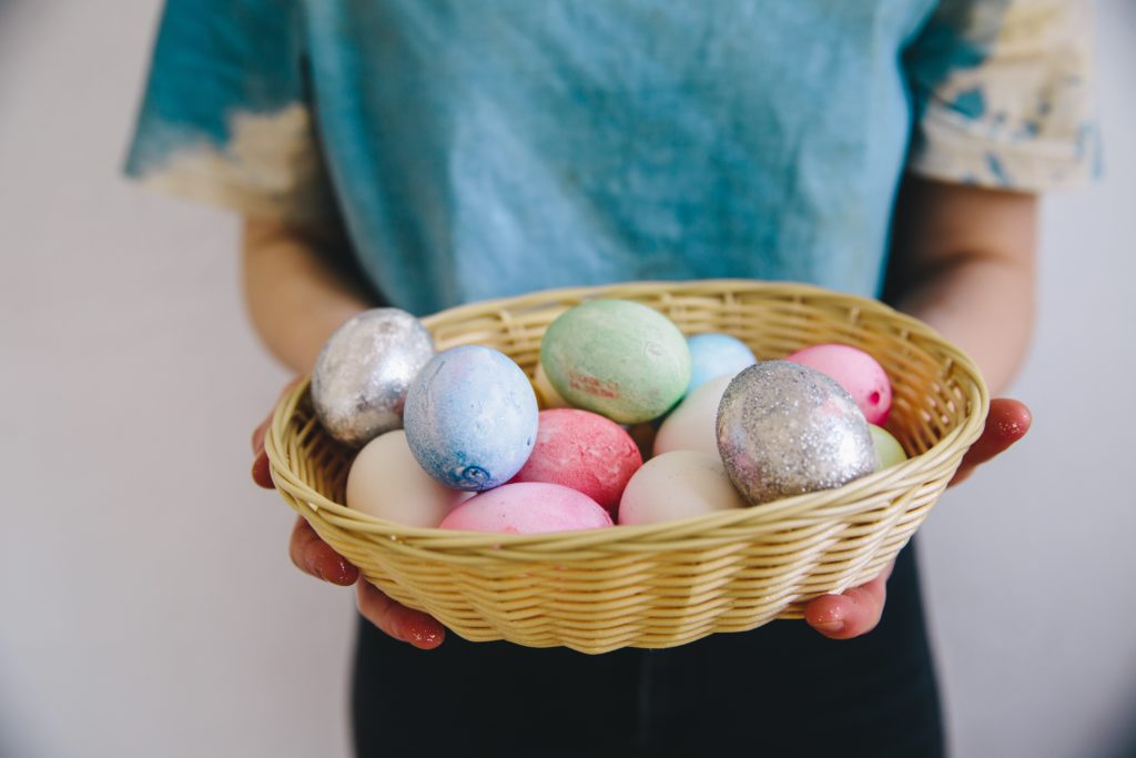 Kid holding a basket with eggs. Thinco easter hunt.